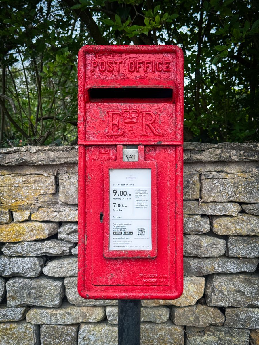 A red Royal Mail post box set into a stone wall